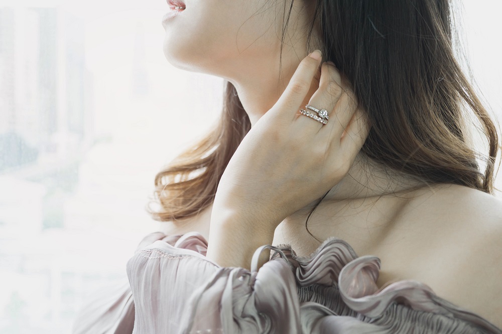 Lady wearing a full gemstone diamond eternity ring with a wedding ring